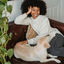 a woman and a dog laying on a couch