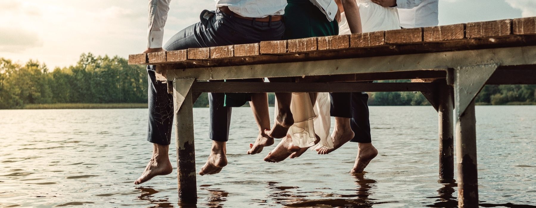 a group of people sitting on a dock over water
