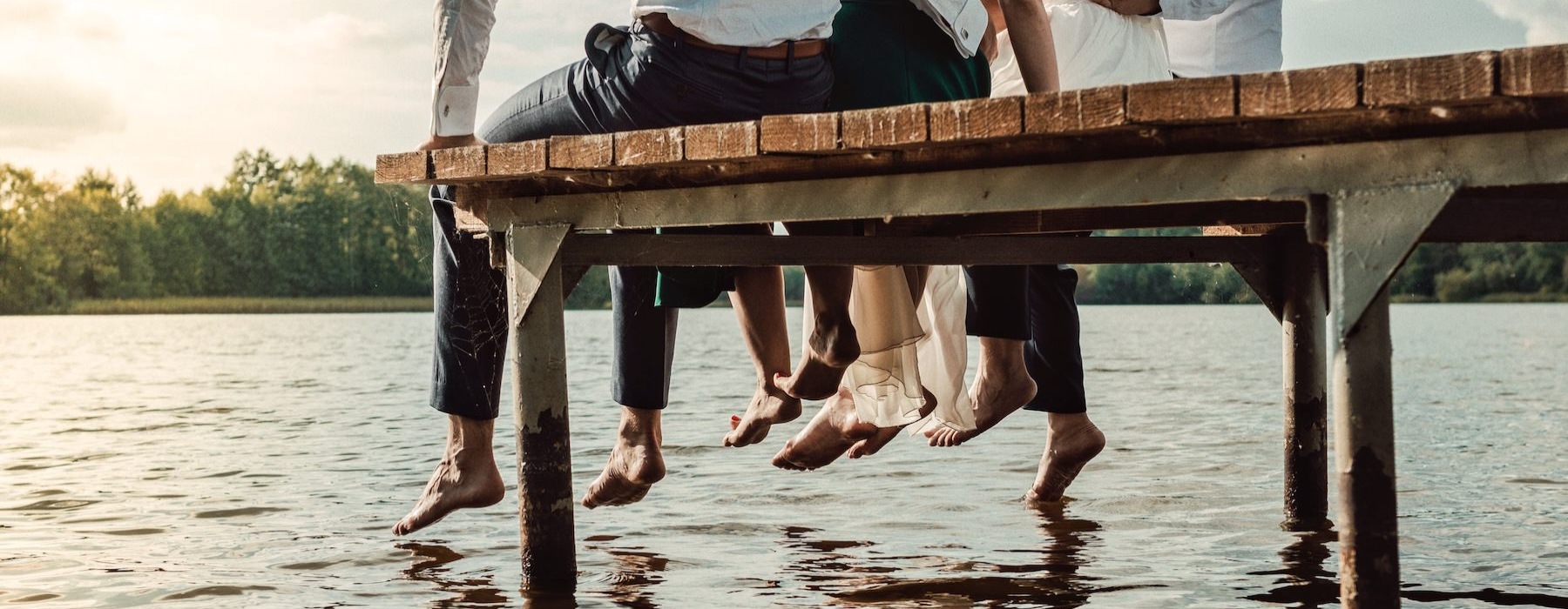a group of people sitting on a dock over water