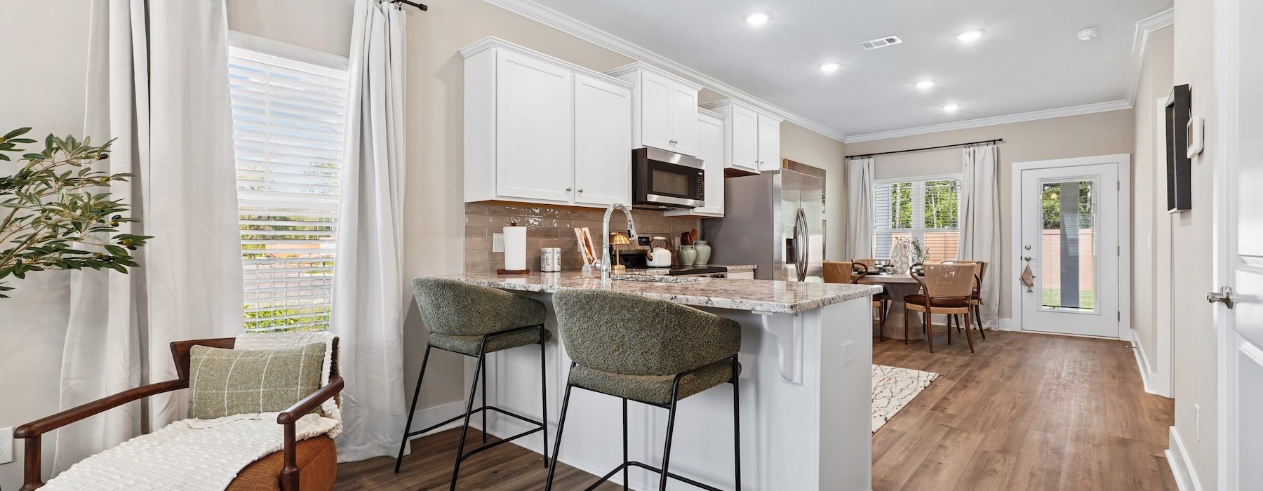 a kitchen with white cabinets and chairs